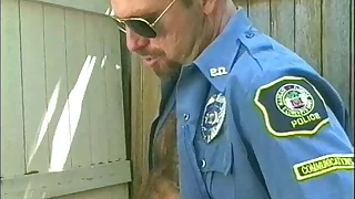 Muscular man in uniform and wearing glasses sucks and blows